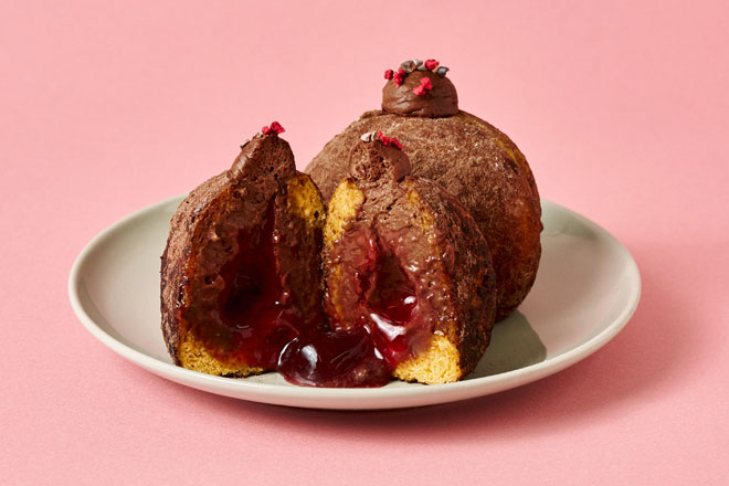 期間限定のラズベリーショコラドーナツが半分に割れて中のベリーソースが流れている